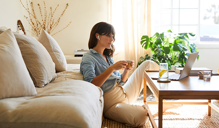 woman sitting on the floor in her living room relaxing and practicing self-care