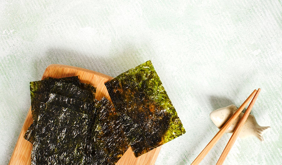 Roasted seaweed snack on wood block with chopsticks 