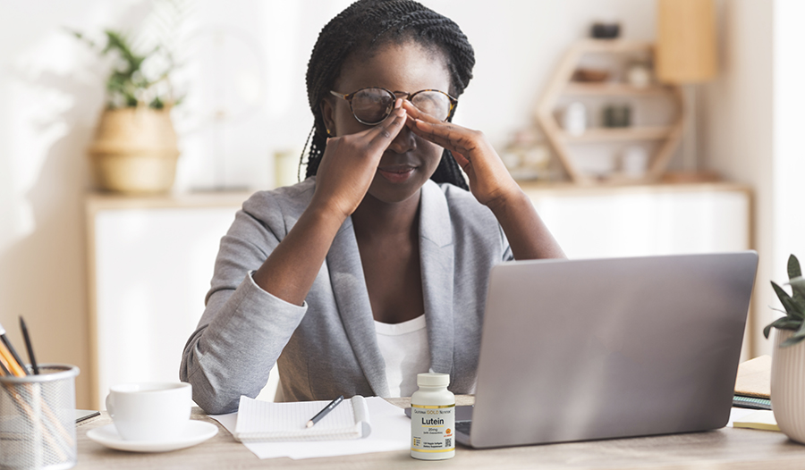 Young professional woman working on her laptop rubbing her eyes 