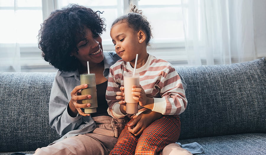 Mother and daughter sharing smoothies at home