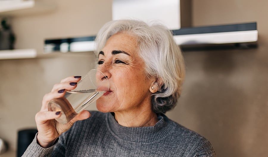 Mature healthy woman drinking glass of water