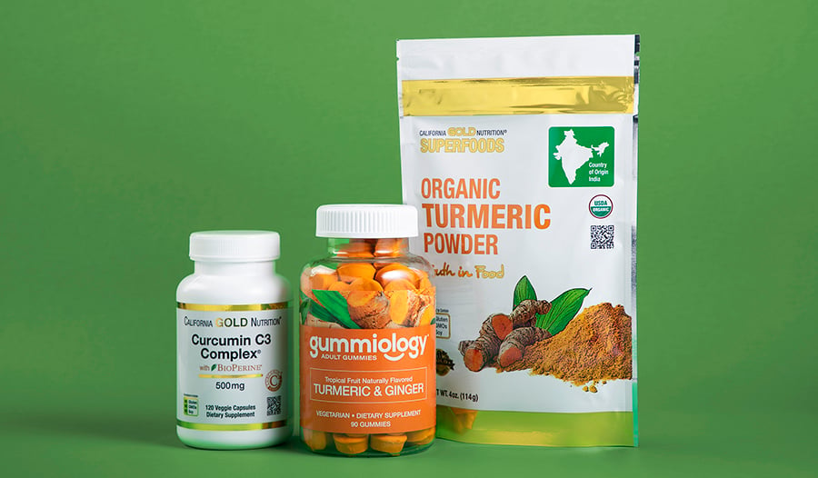 Turmeric supplements in powder, gummy, and capsule form on green background