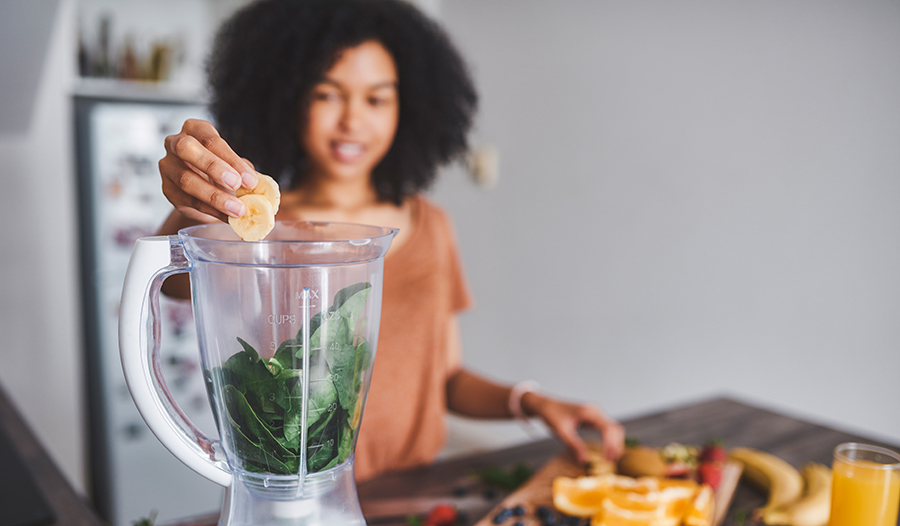 Young woman making a healthy smoothie at home