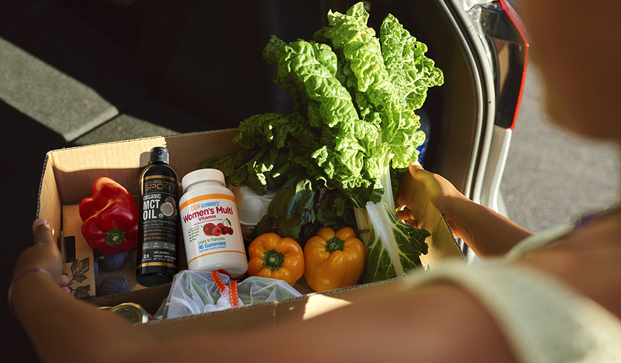 Putting healthy groceries like vegetables, multivitamins, and MCT oil in car